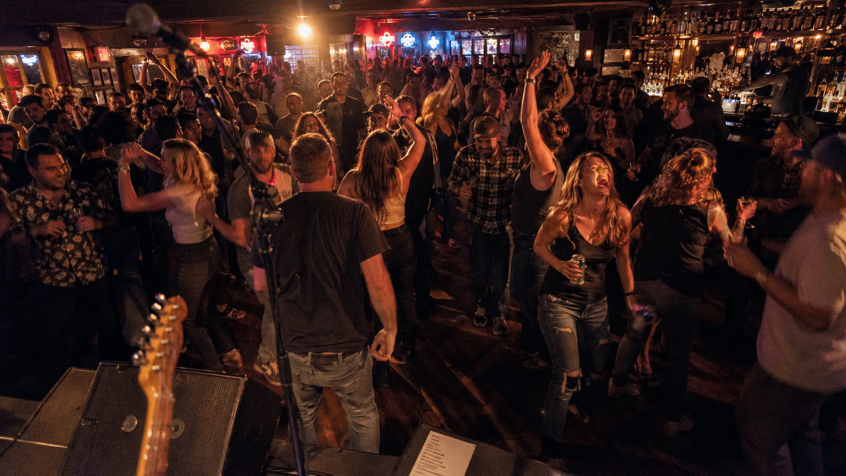 Stage-POV view of a packed bar crowd dancing during a live show